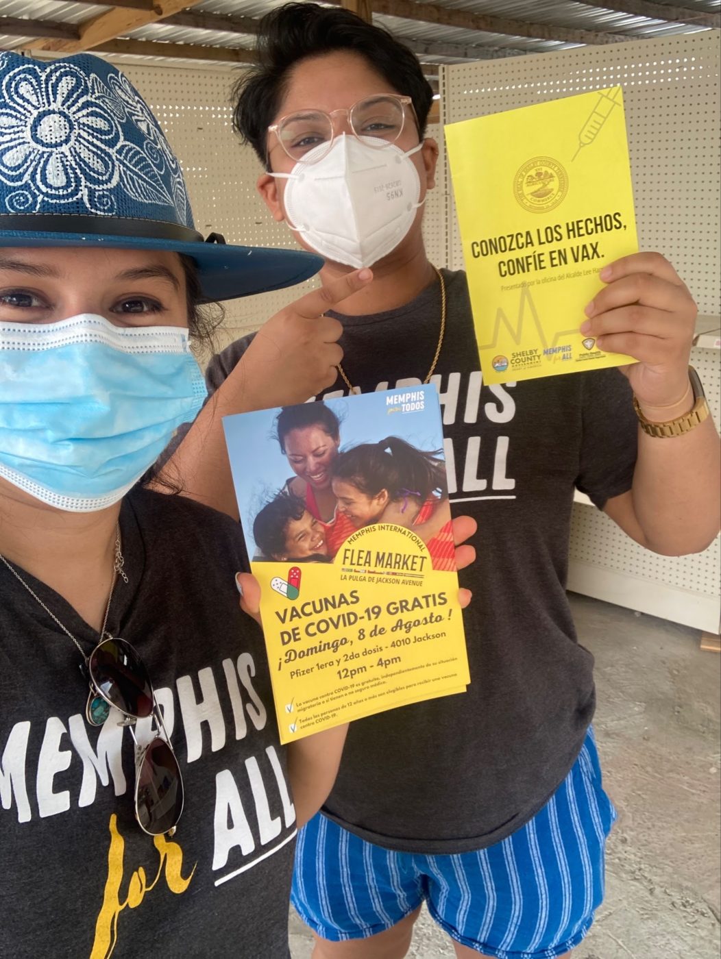 two people holding flyers for vaccines