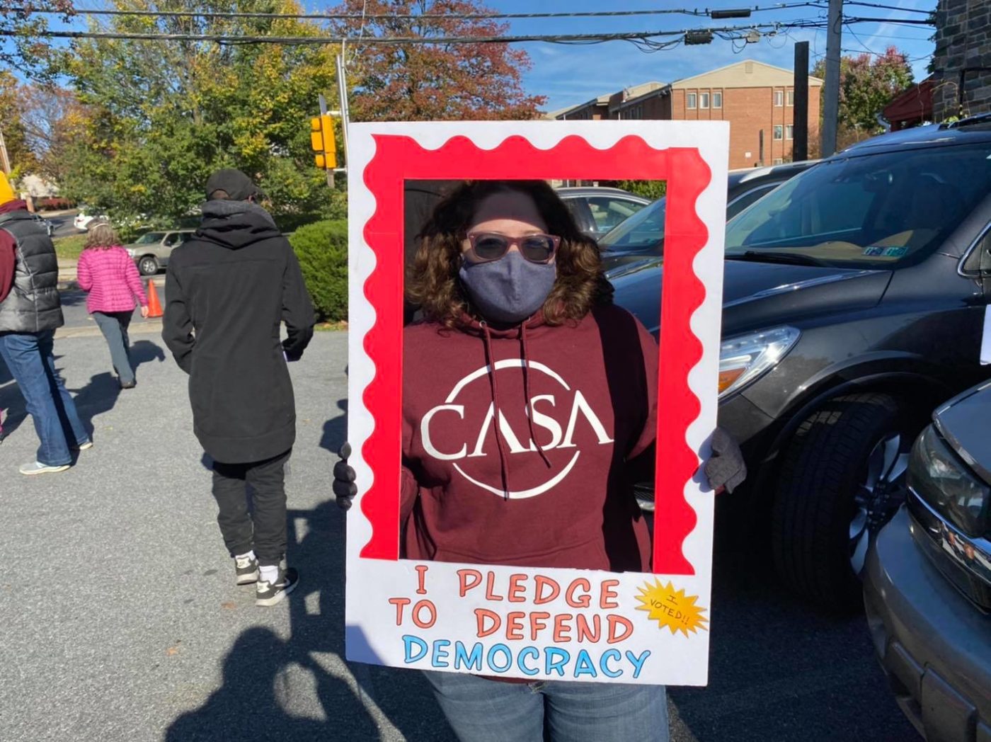 woman with a sign that says I pledge to defend democracy
