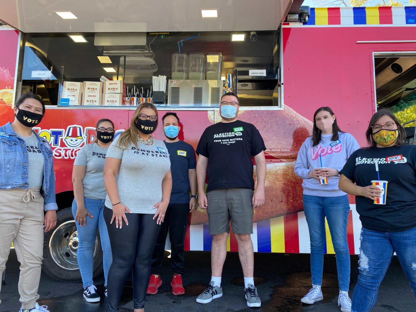 Silver State Voices staff and election protection volunteers pose next to a local food truck.