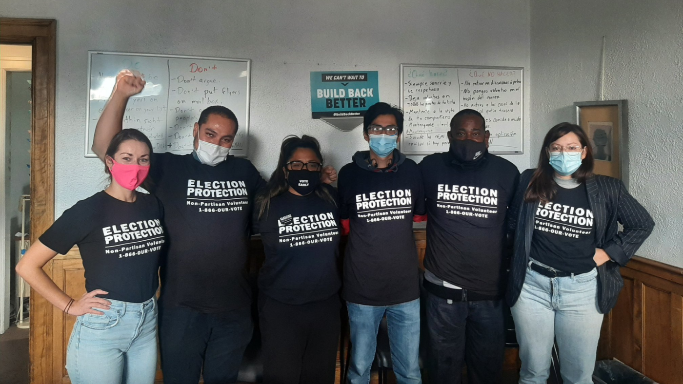 Silver State Voices partners and volunteers stand together wearing masks and election protection branded shirts.