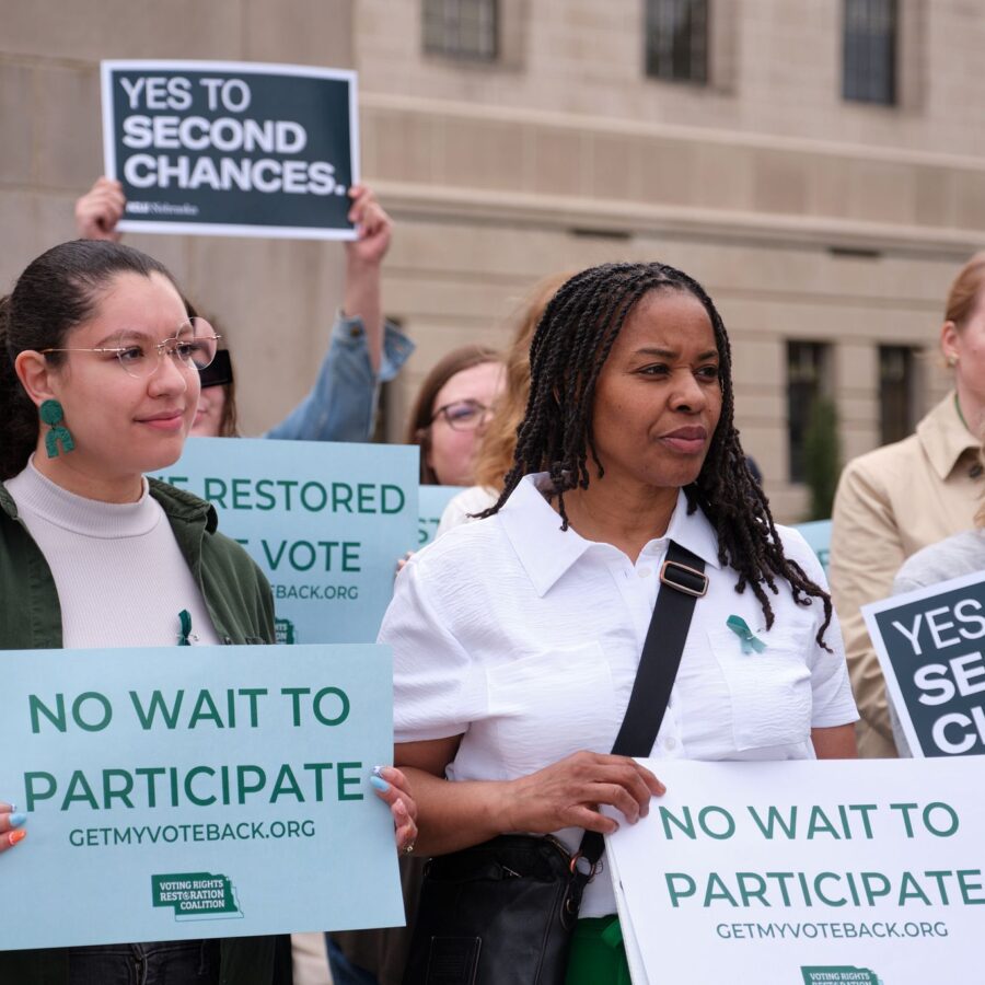 Nebraska advocates stand outside the Nebraska capital building holding signs that read "No wait to participate" and "Yes to second chances."
