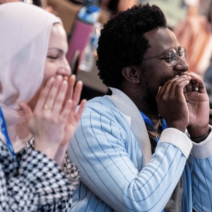 Woman and man with hand cupped around their mouths yelling