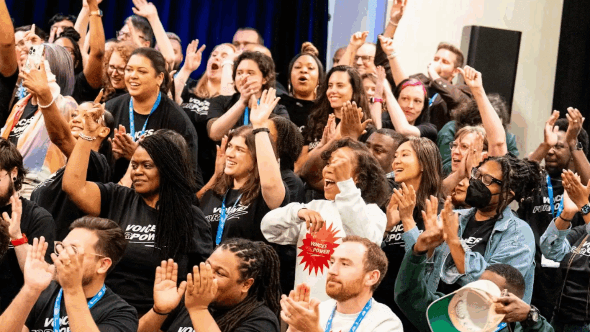 Attendees at State Voices' Network Convening cheer together.